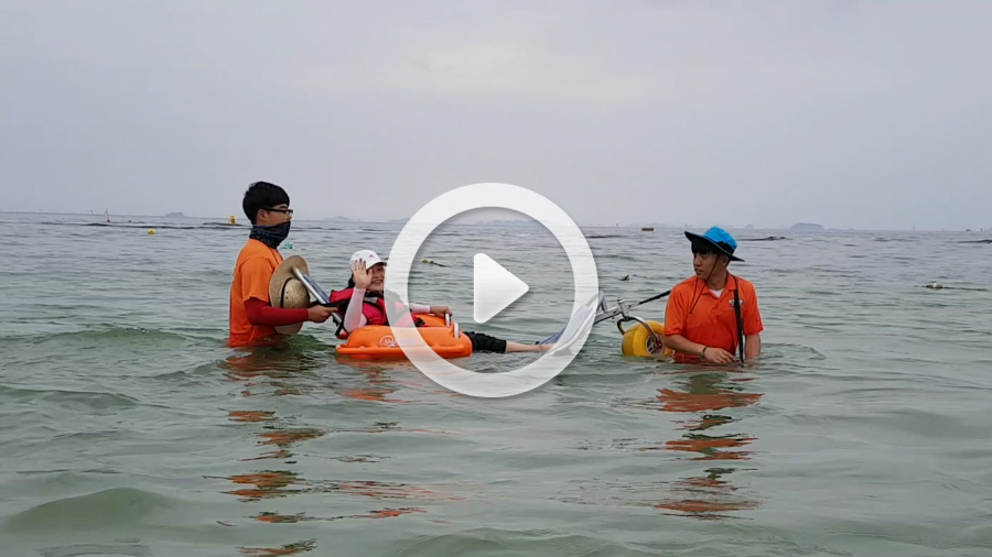 바다에 들어가 수중체어를 이용하고 있는 시민과 도움을 주는 봉사단의 동영상 : 클릭하시면 해당 동영상을 보실수 있는 화면을 제공합니다.